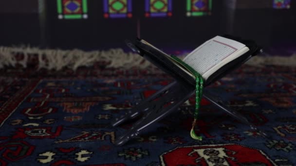 Open heilig boek van moslims op staan op oostelijk tapijt met donker getinte mistige achtergrond. Moslim religie concept. Selectieve focus. Binnenschot. - Video