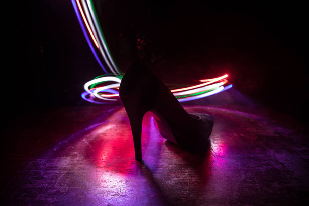 Artwork decoration. Silhouette of a high heel women shoes at dark. Women power or women domination concept. Selective focus - Foto, Imagem