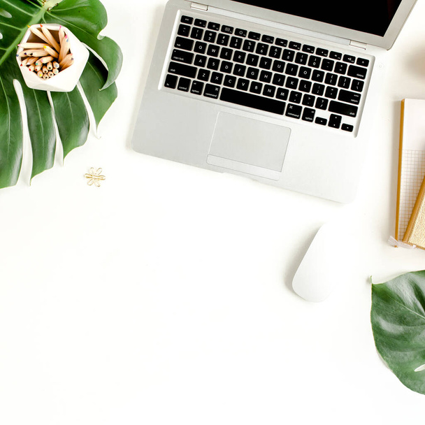 Flat lay home office desk. Female workspace with laptop, tropical palm leaves Monstera, accessories on white background. Top view feminine background - Zdjęcie, obraz