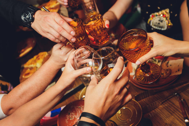 Close up shot of group of people clinking glasses with wine or champagne in front of bokeh background. older people hands. - Zdjęcie, obraz