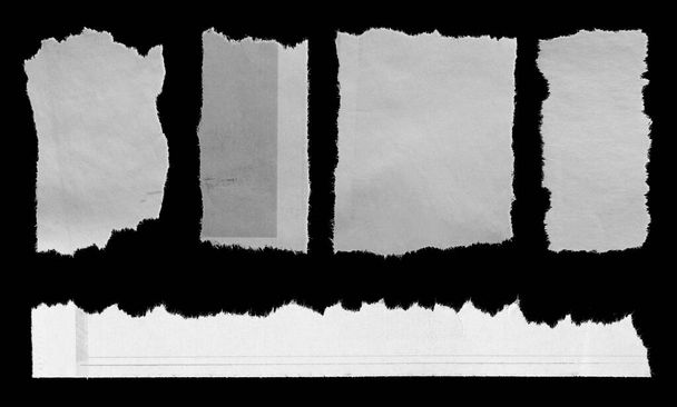 Fünf Stücke zerrissene Zeitung auf schwarzem Hintergrund - Foto, Bild