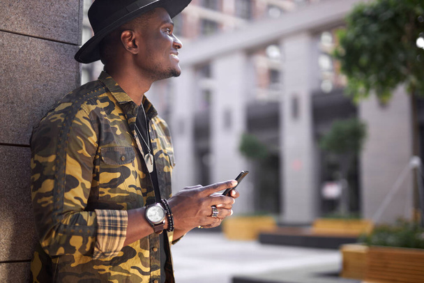 good-looking black male use smartphone while he is walking - Фото, зображення