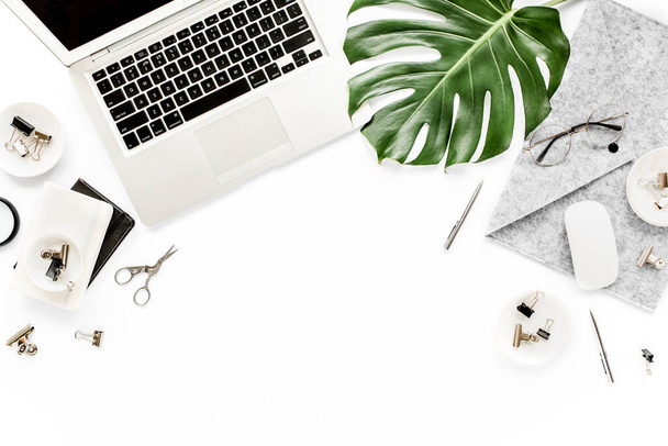 Home office workspace mockup with laptop, tropical leaves Monstera, clipboard, notebook and accessories on white background. Flat lay, top view - Zdjęcie, obraz