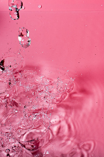 splash of water on a red background. Abstract wallpaper - Fotoğraf, Görsel