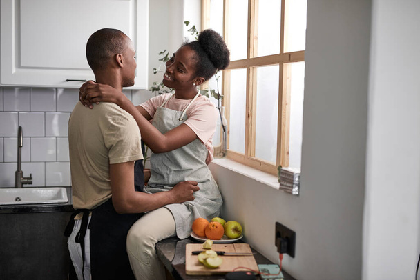 side view on young couple hugging in kitchen - Photo, Image