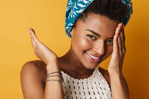 Image of happy african american woman smiling and looking at camera isolated yellow background - Photo, image