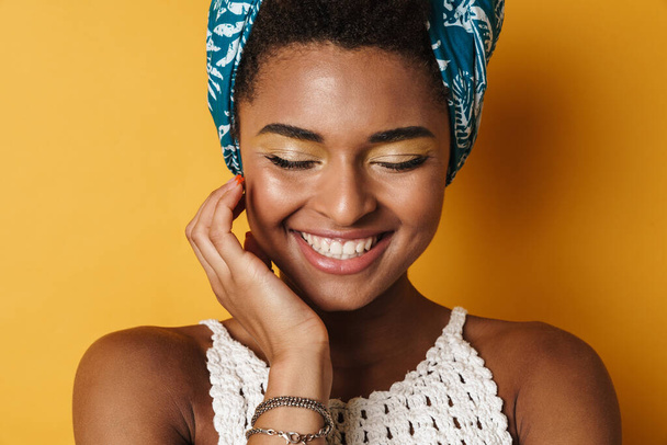 Image of funny african american woman posing and laughing on camera isolated yellow background - Photo, image