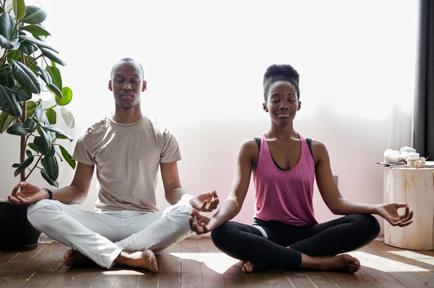 african ameican man and woman meditate, practice yoga at home - Fotoğraf, Görsel