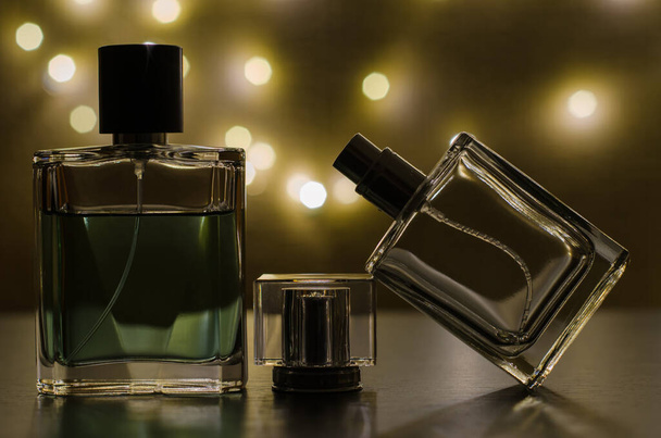 Three bottles of men's perfume on the background of festive lights - Photo, Image