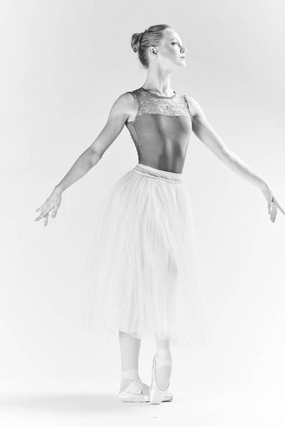 Sivri uçlu ayakkabılı ve etekli kadın balerin, bacak dansı modeli pozu veriyor. - Fotoğraf, Görsel