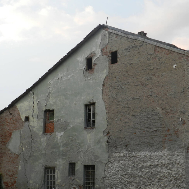 La fachada se cayó de las paredes de un viejo edificio en ruinas con paredes rotas - Foto, Imagen