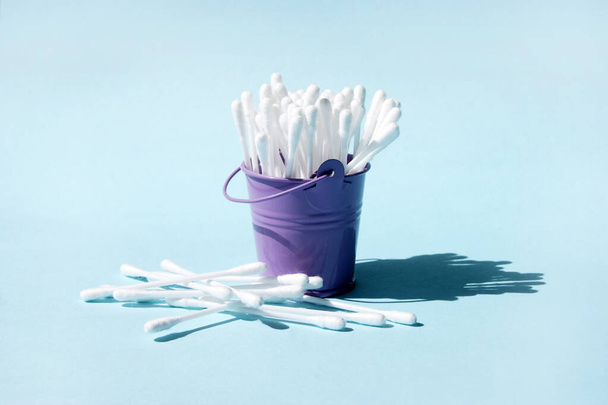 A lot of clean ear sticks in a miniature metal purple bucket. Cotton buds for cleaning ears. Body care. - Photo, Image