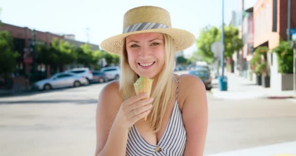 Usmívající se sexy mladá atraktivní žena dívá do kamery a jíst zmrzlinu, 4K - Záběry, video