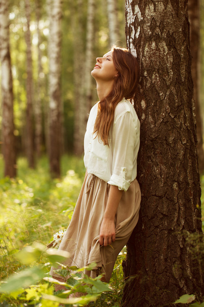 Woman leaning against birch and resting - Photo, image