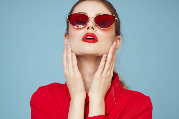 Lovely woman in dark glasses bright makeup red lips glamor blue background - Foto, afbeelding