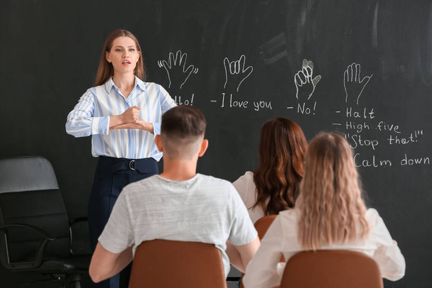 Teacher conducting courses for deaf mute people in classroom - Fotó, kép