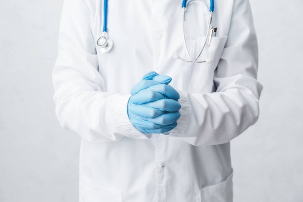 Médico com luvas médicas contra fundo claro - Foto, Imagem
