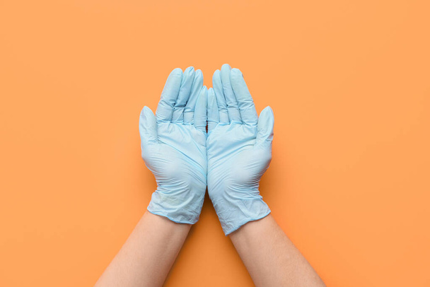 Hands in protective gloves on color background - Photo, Image