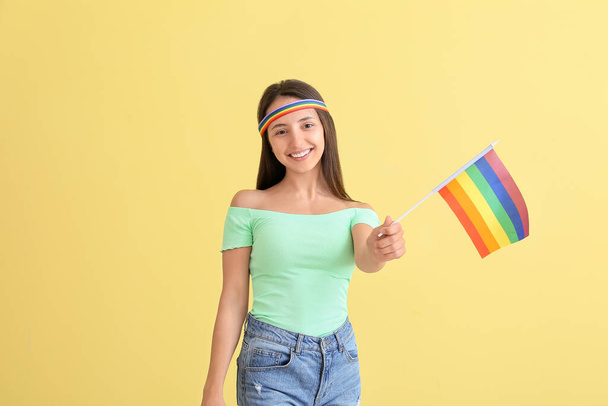 Renkli arka planda LGBT bayrağı olan genç bir kadın - Fotoğraf, Görsel