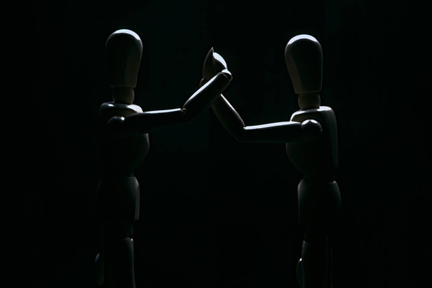 Two drawing mannequins in the act of holding firmly their arms - Фото, изображение
