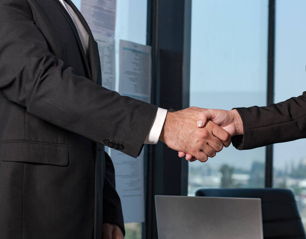 Businessman and businesswoman make handshakes, finishing up meeting. Handshake colleagues in the office - Photo, Image