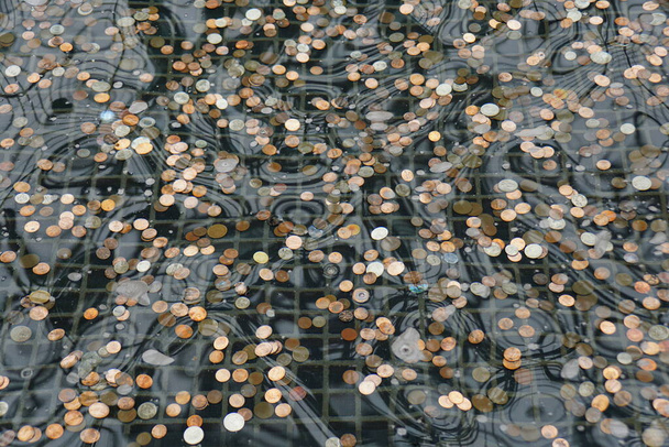 Um monte de moedas dentro de um poço de desejos lagoa - Foto, Imagem