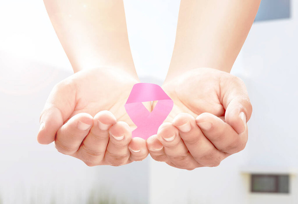 Human hands showing pink awareness ribbon. Breast cancer awareness - Photo, Image