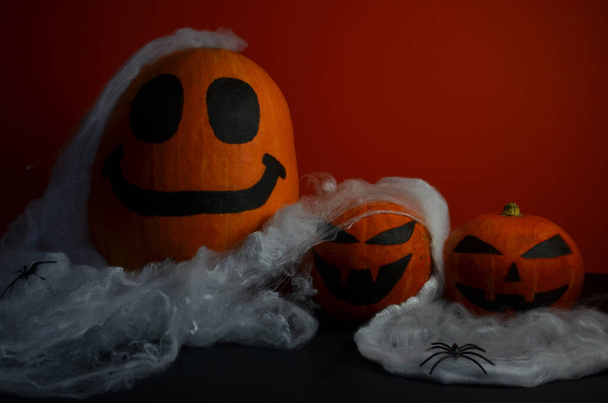 Happy Pumpkin for Halloween on an orange background in a spider web. - Фото, зображення