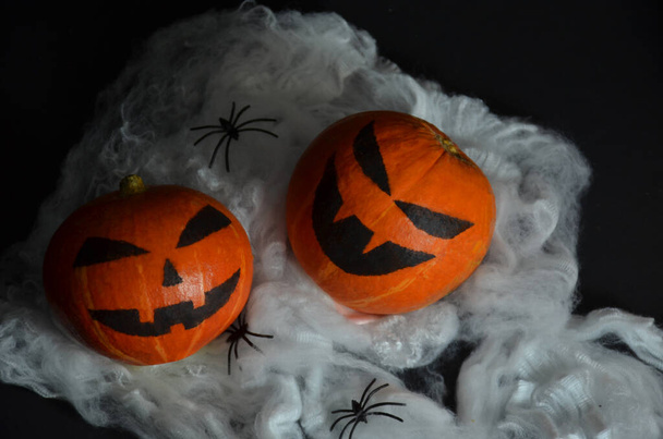 Halloween pumpkin on the web. Spiders on a black background. - Foto, Imagen