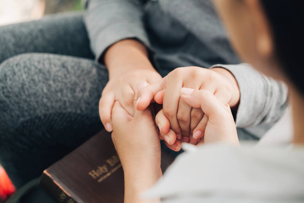 Two women holding hands praying worship believe.Holly bible - Foto, immagini