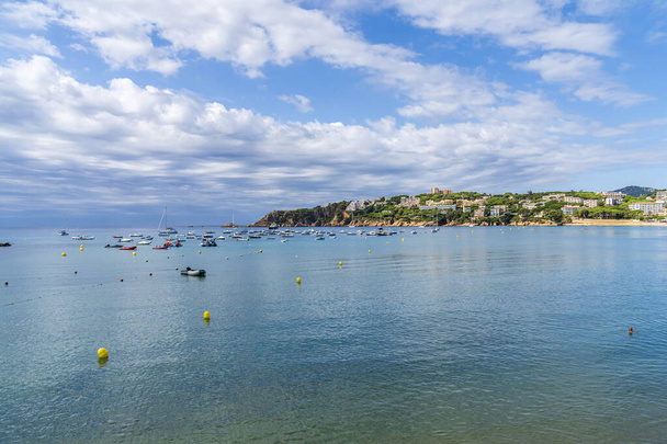 Spiaggia di Sant Pol con barche in mare in una giornata con alcune nuvole bianche, Sant Feliu dels Guixols, Girona, Catalogna, Spagna. - Foto, immagini