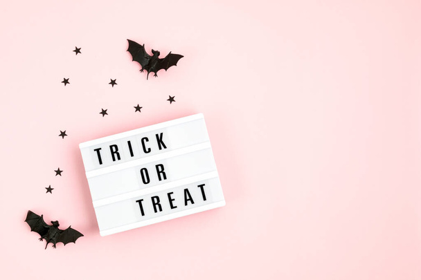 Halloween flat lay of lightbox with Trick or treat text and decoration over pink background. Holiday greeting card, party flyer, invitation concept - Fotó, kép