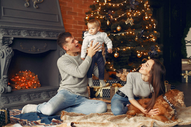 Family with cute dog at home near christmas tree - Photo, Image