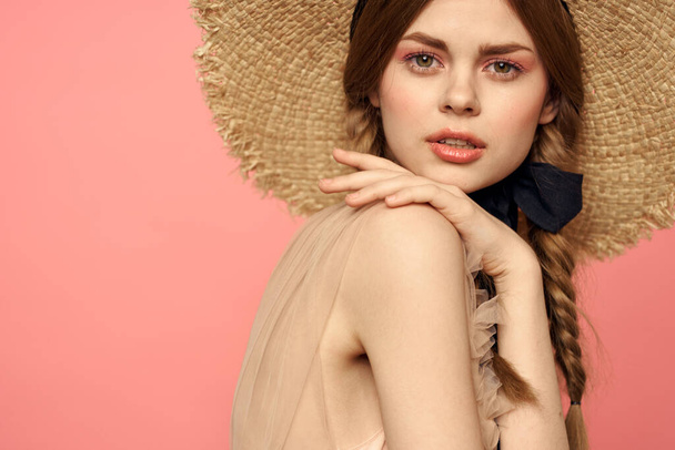 Retrato de una chica en un sombrero de paja sobre un fondo rosa emociones close-up hermosa cara modelo coletas - Foto, imagen