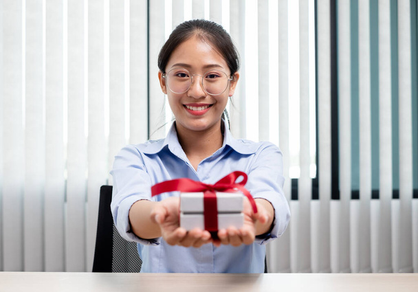 Asyalı kadın bir hediye kutusu tutuyor. Bayramlarda, Noel 'de, doğum günlerinde ya da Sevgililer Günü konseptinde sürpriz yapmaktan mutluluk duyuyor.. - Fotoğraf, Görsel