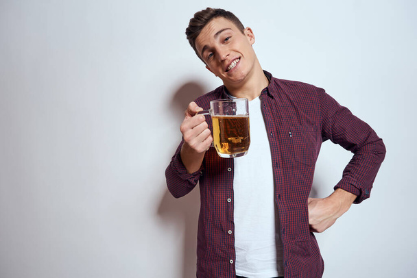 Cheerful man with mug of beer alcohol emotions light background - Фото, зображення