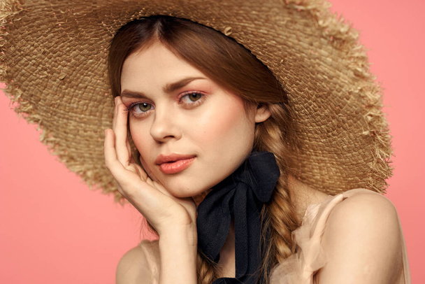 Portrait of a girl in a straw hat on a pink background emotions close-up beautiful face model pigtails - Photo, Image