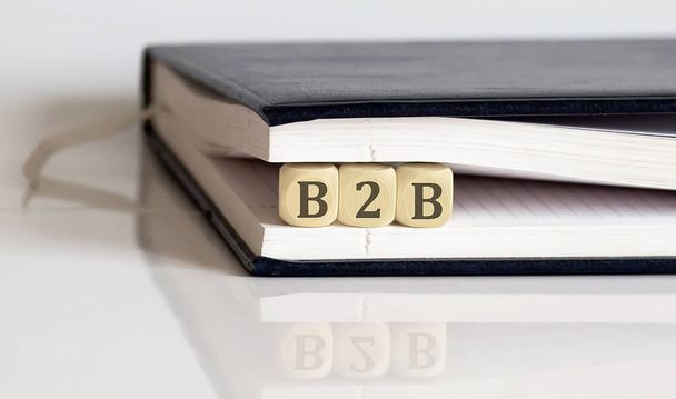 Business to Business Text auf Holzblock im Notizblock auf weißem Hintergrund - Foto, Bild