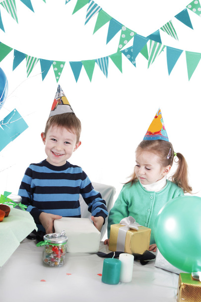 Zwei Kinder an blauem Partytisch beim Eröffnungsgeschenk - Foto, Bild