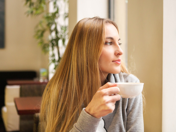 Woman drinking tea in cafe - Foto, imagen