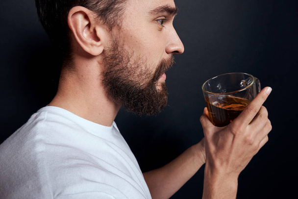 Μεθυσμένος με μια κούπα μπύρα lifestyle αλκοόλ λευκό t-shirt σκούρο φόντο στούντιο περικοπή άποψη - Φωτογραφία, εικόνα