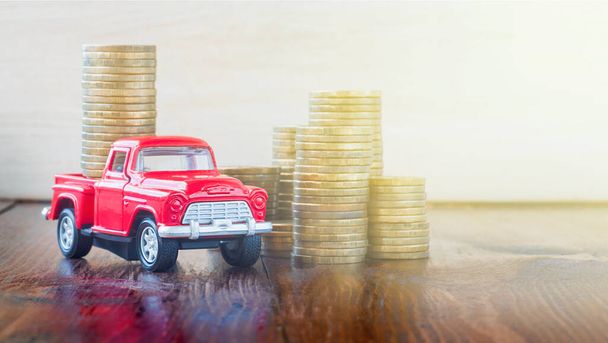 красный автомобиль и монеты на деревянном столе - Фото, изображение