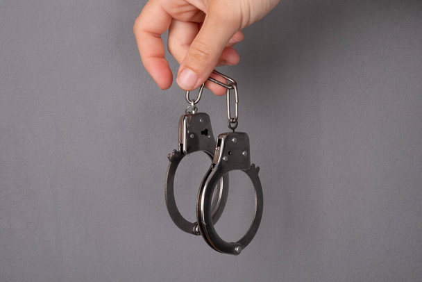 наручники на сером фоне, наказание за преступление  - Фото, изображение