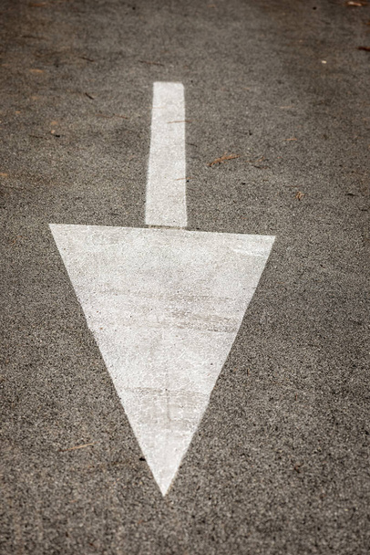 Primer plano de una flecha blanca pintada en el asfalto de una carretera, señal direccional de tráfico en Italia, Europa - Foto, Imagen