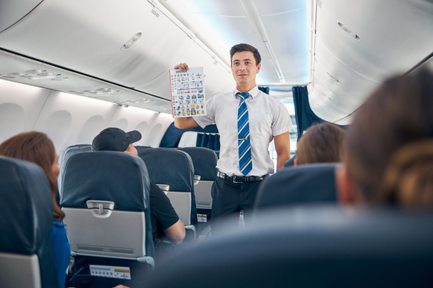 Komea mies, jolla on lentoonlähtöön tarvittava turvallisuustietoluettelo - Valokuva, kuva