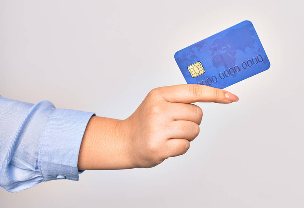 Kéz a kaukázusi fiatal nő gazdaság hitelkártya felett elszigetelt fehér háttér - Fotó, kép