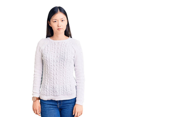 Νεαρή όμορφη Κινέζα γυναίκα φορώντας casual πουλόβερ σκεπτικός και νευρικός, συνοφρυωμένος αναστατωμένος λόγω του προβλήματος. αρνητικό πρόσωπο.  - Φωτογραφία, εικόνα