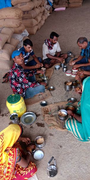 DISTRICT KATNI, INDIA - SEPTEMBER 18, 2019: Indiase dorpsarme arbeider luncht samen bij Raw food grain agriculture market. - Foto, afbeelding