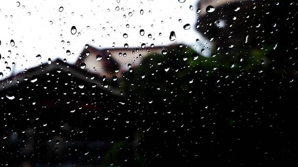 kropla deszczu na szklaną ścianę przezroczystość i zobaczyć miasto w plamie - Zdjęcie, obraz