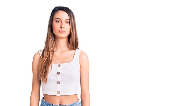 Young beautiful girl wearing casual sleeveless t shirt relaxed with serious expression on face. simple and natural looking at the camera.  - Photo, Image